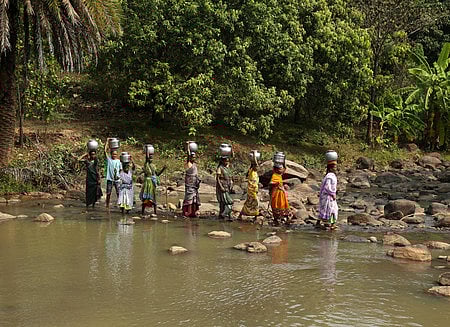 Women crossing the Tandava River stream