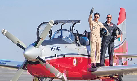 BJP MP Tejasvi Surya raises the victory sign from the wing of an HTT-40 aircraft