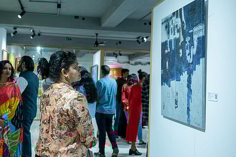 A visitor observes a piece of art at the exhibition 'Love Affair' in Anantyam Qalaa Art Gallery