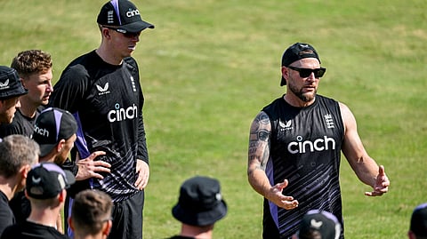 England's head coach Brendon McCullum (R) speaks to players during a practice session.