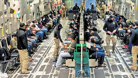 Cuffed and shackled illegal Indian migrants being deported on a US military aircraft.