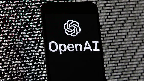The OpenAI logo appears on a mobile phone in front of a computer screen with random binary data, March 9, 2023, in Boston.