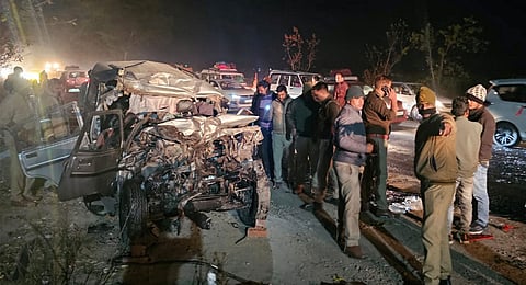 Police personnel and other people at the site after a collision between a bus and a Bolero car, which was carrying devotees to the Maha Kumbh, on a highway in the Meja police station area of Prayagraj, late on Friday night, Feb. 14, 2025. 
