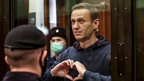 In this image made from a video provided by Moscow City Court, Russian opposition leader Alexei Navalny makes a heart symbol while standing in the defendants’ cage during a hearing into his 2014 criminal conviction in Moscow, Russia, on Feb. 2, 2021.
