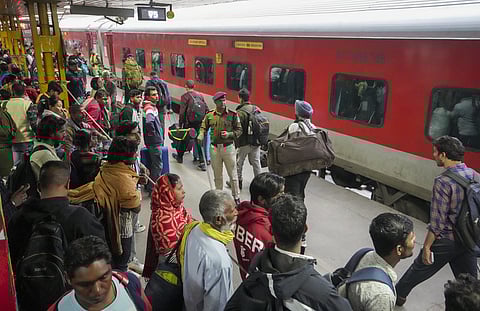 An RPF personnel stands guard to control the crowd at the New Delhi railway station after a stampede occurred on February 15, 2025. 