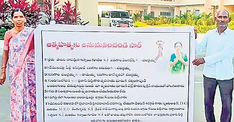 A couple display a banner in front of the Bhupalpally Collectorate for permission to die by suicide due to alleged harassment by SI on Tuesday