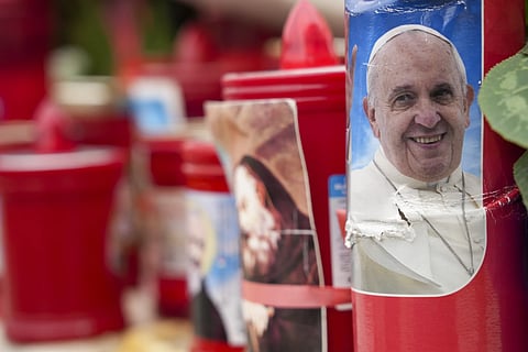 A candle with a portrait of Pope Francis is seen in front of the Agostino Gemelli Polyclinic in Rome, Tuesday, Feb 18, 2025, where Pope Francis has been hospitalised to undergo some necessary diagnostic tests and to continue his ongoing treatment for bronchitis.