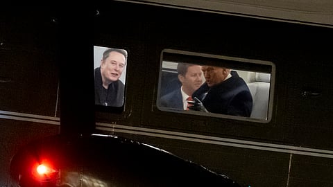 Elon Musk, left, and US President Donald Trump, right, are seen through the windows as Marine One lands on the South Lawn of the White House, Wednesday, Feb. 19, 2025, in Washington.