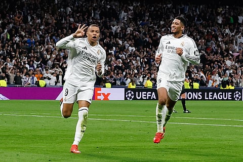Real Madrid's Kylian Mbappe (L) celebrates scoring his third goal for a hat trick during the UEFA Champions League knockout phase play-off football match between Real Madrid CF and Manchester City  on February 19, 2025.