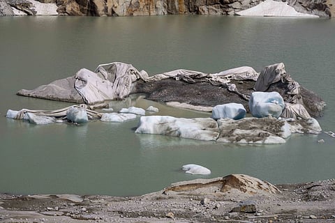 Chunks of ice float in a lake in front of Rhone Glacier near Goms, Switzerland, June 15, 2023.