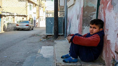 A boy sits in a alley in a Palestinian refugee camp in Jerash, north of Amman, which was established in Jordan to host Palestinians who fled the Gaza Strip during the 1967 Arab-Israeli war, on February 18, 2025. 