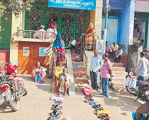 Footwears of farmers lined up in front of Aska Central Co-operative Bank at Sorada