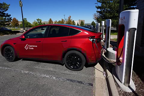 A Tesla Model 3 charges at a Tesla supercharging station situated in the parking lot of an outlet mall on Sept. 25, 2024, in Lakewood, Colo. 