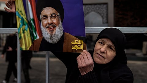 An Hezbollah supporter holds a picture of the late Lebanon's Hezbollah leader Sayyed Hassan Nasrallah, who was killed on Sept. 27, 2024 by Israeli airstrikes, as she stands at the burial site during preparations a day ahead of his public funeral procession in Beirut, Lebanon, Saturday, Feb. 22, 2025. 