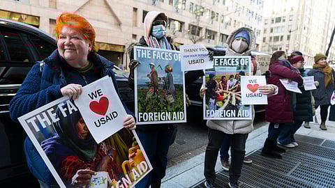 Retired USAID worker Julie Hanson Swanson, left, joins supporters of fellow agency workers outside the USAID's Bureau of Humanitarian Affairs office in Washington, Friday, Feb. 21, 2025.