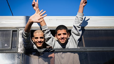 Freed Palestinian teenagers wave as they are greeted upon their arrival after being released from detention in an Israeli prison in Khan Younis, Gaza Strip, Thursday, Feb. 27, 2025.