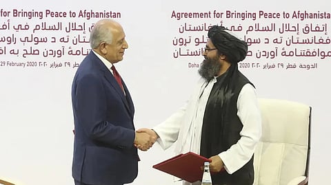 In this Feb. 29, 2020, file photo, US peace envoy Zalmay Khalilzad, left, and Mullah Abdul Ghani Baradar, the Taliban group’s top political leader, shack hands after signing a peace agreement between Taliban and U.S. officials in Doha, Qatar. 