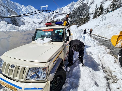 Snow being removed as a police vehicle stuck after snowfall, at the South Portal of Atal Tunnel, in Kullu district, Saturday, March 1, 2025.
