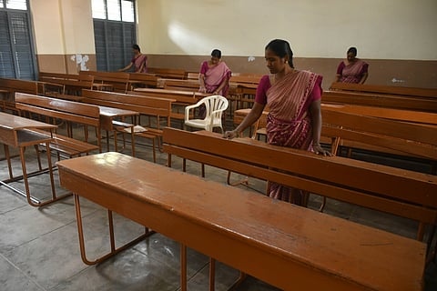Staff writes the hall ticket number on the benches a day ahead of the commencement of Intermediate examinations at a college in Vijayawada on Friday.