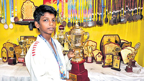 Raja displays the trophies he had won in various judo tournaments 