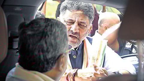 Deputy Chief Minister DK Shivakumar has a word with Chief Minister Siddaramaiah, who is seated inside his car, before the joint session of the legislature at Vidhana Soudha on Monday.