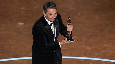Sean Baker accepts the award for best original screenplay for "Anora" during the Oscars on Sunday, March 2, 2025, at the Dolby Theatre in Los Angeles. 
