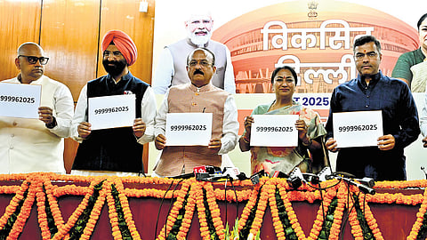 Delhi Chief Minister Rekha Gupta with Cabinet Ministers Ashish Sood and Parvesh Verma, Manjinder Singh Sirsa show the Viksit Bharat contact details where people can send their suggestions on Viksit Delhi Budget 2025-26.
