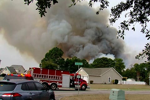 Crews work to contain a fire in the Carolina Forest area west of the coastal resort city of Myrtle Beach, S.C., Sunday, March 2, 2025., where residents were ordered to evacuate several neighborhoods.