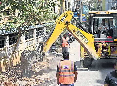 HYDRAA personnel clear encroachments from a road in Nizampet on Tuesday