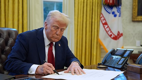 US President Donald Trump signs a document in the Oval Office at the White House, Jan. 30, 2025, in Washington.
