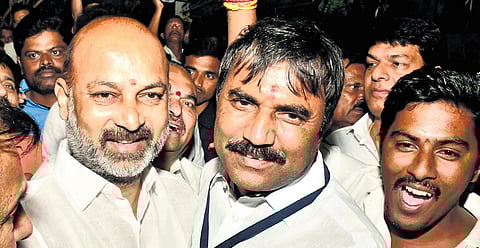 BJP candidate C Anji Reddy shares his joy at winning the Graduates MLC seat with Minister of State Bandi Sanjay in Karimnagar on Wednesday