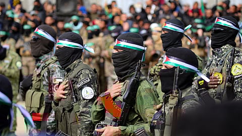 In this photo from February 22, 2025, Palestinians and Hamas fighters gather shortly before the seventh hostage-prisoner swap in Nuseirat in the central Gaza Strip.