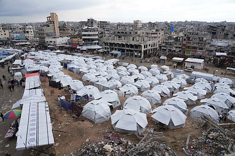 A sprawling tent camp for displaced Palestinians sits adjacent to destroyed homes and buildings in Gaza City, Gaza Strip, Saturday, March 1, 2025, during the Muslim holy month of Ramadan.