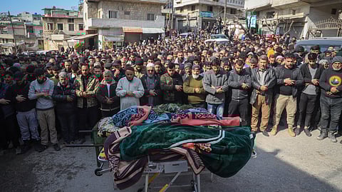 Village male residents pray during the funeral of four Syrian security force members killed in clashes with loyalists of ousted President Bashar Assad in coastal Syria, in the village of Al-Janoudiya, west of Idlib, Saturday, March 8, 2025. 