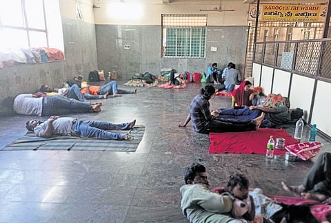 Attendants of patients sleep on the floor due to lack of seating facilities in the AMC building of Gandhi Hospital in Secunderabad 