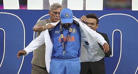 India's captain Rohit Sharma receives the white coat from BCCI President Roger Binny during the presentation ceremony of the ICC Champions Trophy after their win against New Zealand at Dubai International Cricket Stadium in Dubai, United Arab Emirates, Sunday, March 9, 2025. 