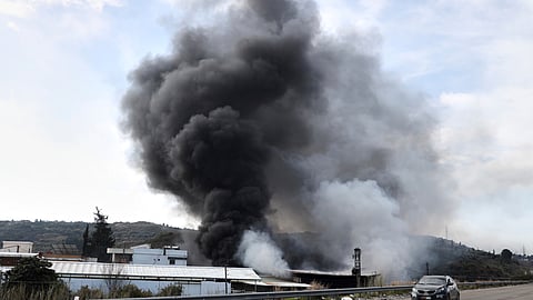 Smoke rises from a factory hit during clashes by Syrian security forces and gunmen loyal to former President Bashar Assad in the outskirts of Latakia, Syria, Friday, March 7, 2025.