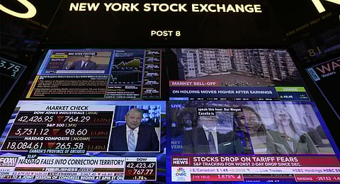 Financial news is displayed as people work on the floor at the New York Stock Exchange in New York, Tuesday, March 4, 2025. 