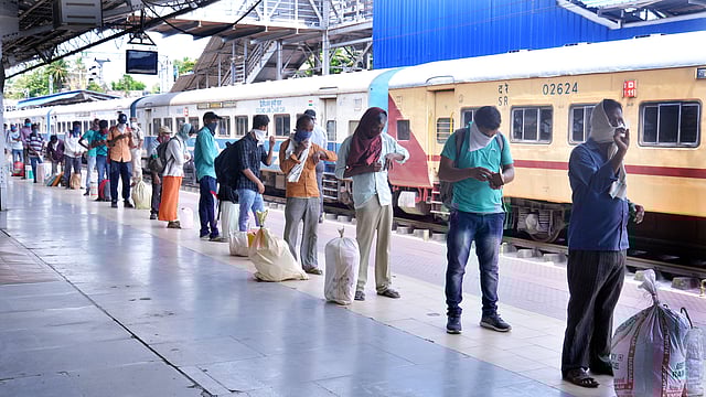 Migrant workers line up to depart for their native places at the Thiruvananthapuram Central Railway Station
