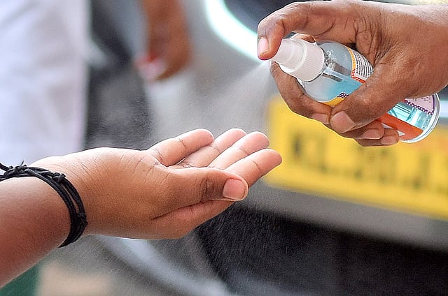 A health worker spraying hand-sanitiser for a student in Thiruvananthapuram 