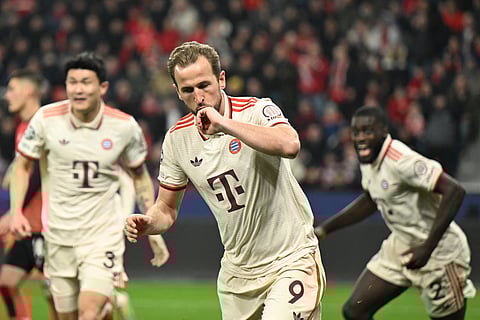Bayern Munich's Harry Kane (R) celebrates scoring the opening 0-1 goal during the UEFA Champions League last 16, second leg, football match between Bayer Leverkusen and Bayern Munich in Leverkusen, western Germany on March 11, 2025.