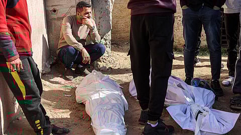 Mourners gather by the shrouded bodies of victims killed by Israeli bombardment in Beit Lahia in the northern Gaza Strip, outside the Indonesian hospital in Beit Lahia on March 15, 2025.