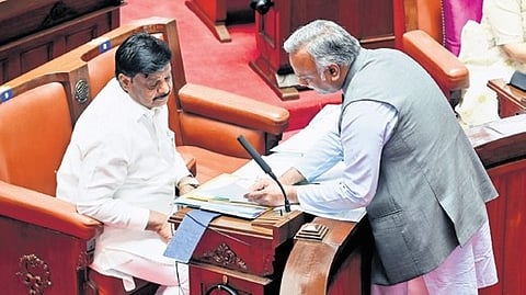 Ministers Priyank Kharge and HC Mahadevappa discuss a point in the Council on Friday.