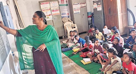 Students listen to a teacher at the government primary school in Gattubhoothkur, Gangadhara mandal, in Karimnagar district.