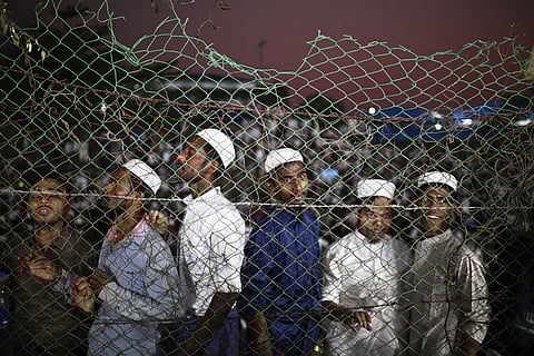 Rohingya refugees gather behind a fence to look at UN Secretary -General  António Guterres who visited the  Ukhiya camp in Cox's Bazar, in Bangladesh, Friday, March 14, 2025.