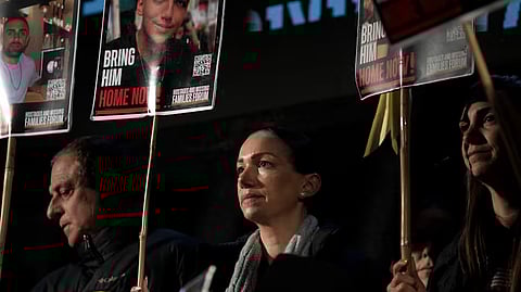 Yael Alexander holds a poster of her son, Edan, who was taken hostage by Hamas militants on Oct. 7, 2023, during a weekly rally for families of hostages held in the Gaza Strip and their supporters, in Tel Aviv, Israel, Saturday, Feb. 22, 2025.