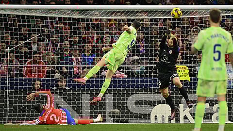 Barcelona's Polish forward #09 Robert Lewandowski heads the ball during the Spanish league footbal match between Club Atletico de Madrid and FC Barcelona at Metropolitano Stadium in Madrid, on March 16, 2025.