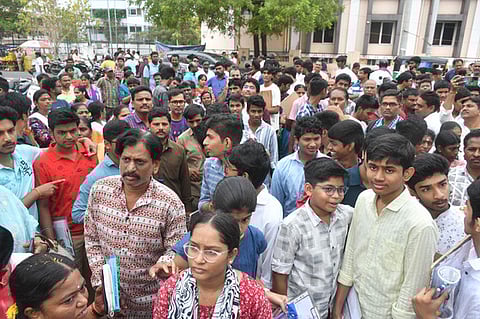Students and parents wait outside the examination centre as on the first day of SSC exam in Vijayawada on Monday. 