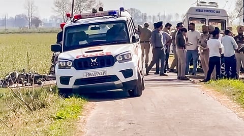 Police personnel and others gather after a suspect in the blast incident outside a temple in Amritsar was killed in an exchange of fire with police, in Amritsar district.