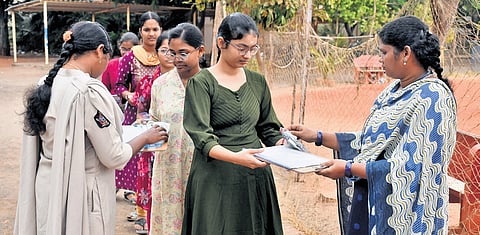 Hall tickets of students being verified at an exam centre.